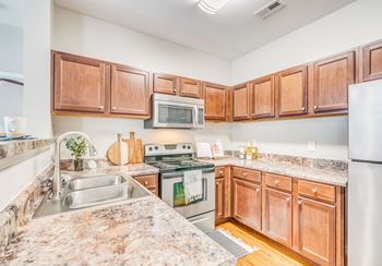 a kitchen with wooden cabinets and stainless steel appliances and granite counter tops